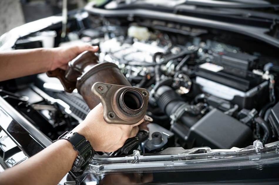 Close-up-old-catalytic-converter-in-hand-1370877378 Car service man remove from engine gasoline car dust clogged condition on filter in service