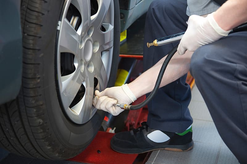 mechanic checking tire pressure